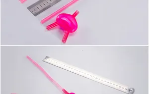 Close-up detail shot of pink plastic novelty drinking straws with heart shape connector and ruler.
