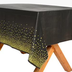 Nappe jetable à pois noirs et dorés pour décoration de table de fête d'anniversaire vue principale.