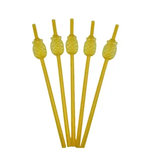 Detail view of yellow plastic pineapple shaped drinking straws, showing close-up of party decor.