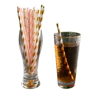 Disposable biodegradable paper straws set with gold foil and pink striped patterns for party drinks.