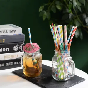 Colorful paper drinking straws with cute umbrellas in glass jar for party decor.