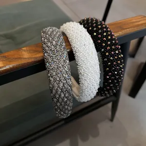 Gedetailleerde opname van drie stijlvolle haarbanden met kralen in zilver, wit en zwart.