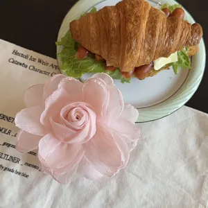 Pince à cheveux fleur en tissu rose doux français, accessoire esthétique élégant.