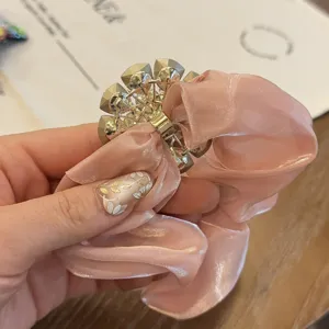 Gros plan détaillé d'un chouchou rose luxueux avec un superbe centre en strass.