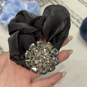 Élégant chouchou de cheveux en satin noir orné d'une superbe fleur en strass de cristal étincelant.
