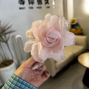 Vue détaillée d'une pince à cheveux fleur en tissu rose style français pour un usage quotidien.