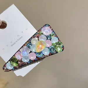 Nahaufnahme Detail einer glitzernden Kristall Dreieck Haarspange mit bunten Strasssteinen.
