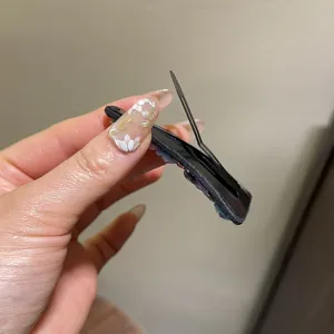 Nahaufnahme der schwarzen Kristall Haarklammer mit robuster Metall Schnappmechanik Detail.