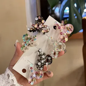 Primer plano detallado de mini pinzas para el cabello brillantes con pedrería.