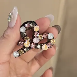 Detalle de pinza para el pelo con pedrería, con cristales brillantes en un diseño de corazón.