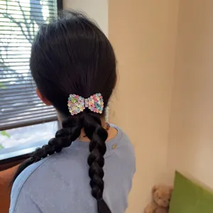 Gedetailleerd uitzicht op een prachtige meerkleurige strass strik haarspeld als accessoire.