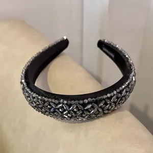 Detailed shot of a baroque crystal beaded black velvet headband, elegant hair accessory.