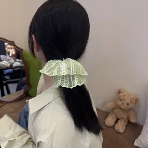 Detailansicht eines süßen grünen Spitzen-Haargummis, elegantes Haarzubehör für Frauen u. Mädchen.