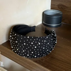 Gedetailleerde close-up van een brede zwarte strass haarband, elegant haaraccessoire.
