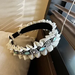Detailed shot of a Korean-style vintage rhinestone ruffled headband with blue gems.