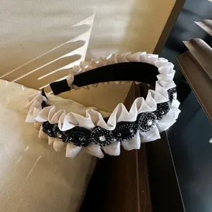 Detailed view of the vintage pleated rhinestone headband with black beads and ruffle edge.