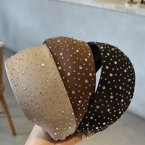 Close-up van strass-versierde brede haarbanden in champagne bruin en zwart voor een stijl