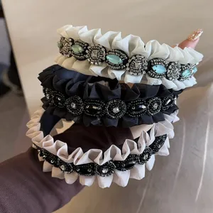 Close-up of vintage ruffled rhinestone headbands featuring crystal beadwork and delicate pleated edges.