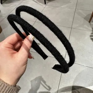 Detailaufnahme des minimalistischen schwarzen Haarreifs aus Garn im Doppelstrang-Look.