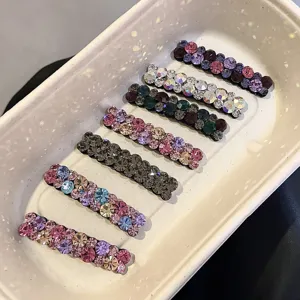 Gros plan détail pinces à cheveux strass colorés, barrettes cristal scintillantes.