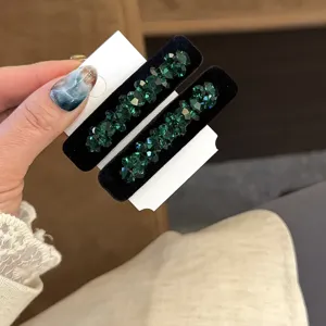 Vue détail pinces à cheveux en velours cristal vert foncé, strass élégants pour femmes.