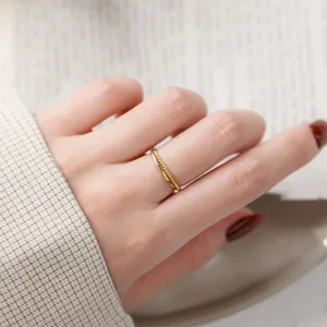 Vue en gros plan détaillée d'une bague double en argent plaqué or 14k torsadé et lisse.