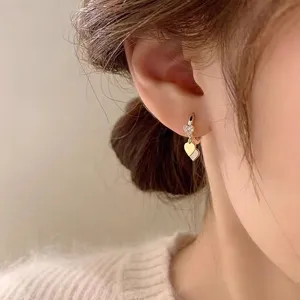 Gros plan détaillé des boucles d'oreilles créoles cœur plaquées or 14k avec oxydes.