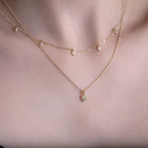 Διπλό λεπτό χρυσό κολιέ με αστραφτερά μενταγιόν ζιργκόν για κομψή εμφάνιση.