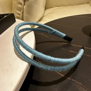Detailansicht des blauen Haarreifs mit doppelten Wollsträngen, weiche Textur im Nahbereich.