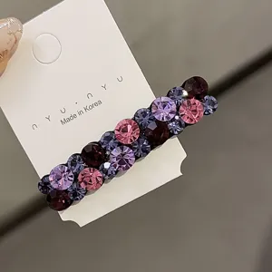 Gros plan détaillé d'une superbe pince à cheveux en strass avec des cristaux roses et violets.