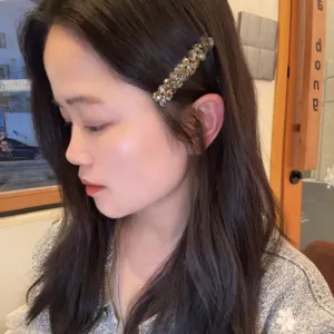 Gros plan détaillé d'une pince à cheveux en strass scintillante pour des coiffures élégantes.