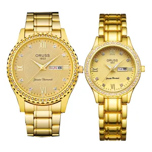 Vue détaillée de montres quartz dorées de couple avec lunette en cristal et chiffres romains.