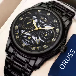 Detail view of a luxury black men's watch with gold hands and sparkling rhinestone markers.