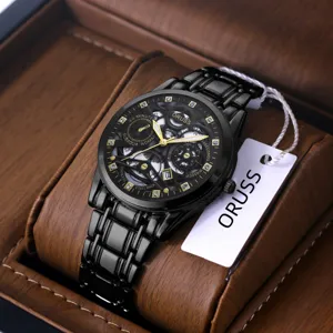 Detailed close-up view of the black men's skeleton watch with gold hands and rhinestones.