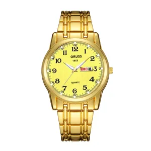 Close-up of the gold watch dial featuring yellow background, clear Arabic numerals, and calendar.