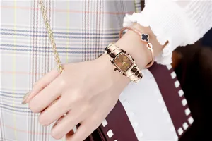 Close-up detail view of a stylish rose gold rectangular quartz women watch with steel strap.