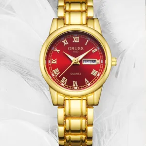 Vue détaillée de la montre quartz dorée pour femme avec cadran rouge et affichage de la date.