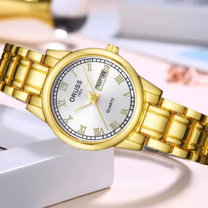 Montre quartz dorée pour femme avec cadran blanc, chiffres romains et affichage double calendrier.