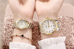 Close-up detail view of elegant couple quartz watches with two-tone steel straps and dials.