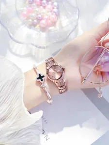 Detailed shot of rose gold quartz watch and clover bracelet on wrist with elegant accessories.