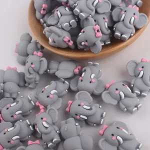 Gros plan de perles d'éléphant en silicone gris mignon avec des nœuds roses pour le bricolage DIY.