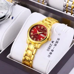 Close-up detail of luxury gold quartz watch with striking red dial and elegant Roman numerals.