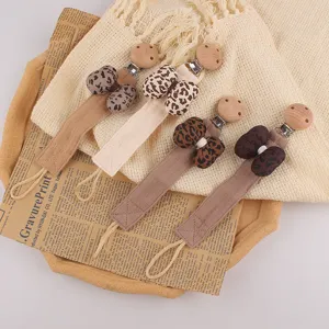 Attache-tétine pour bébé chaîne anti-perte avec nœud léopard clip en bois et sangle en tissu.