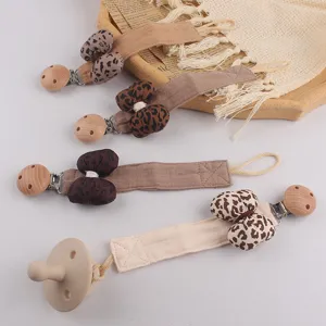 Attache tetine bebe noeud leopard pince en bois fait main laniere en coton chaine anti-chute detail