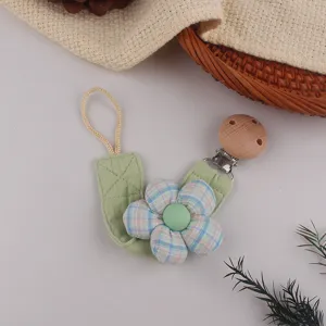 Detailed view of baby pacifier clip with floral fabric design and wooden fastener safe utility.