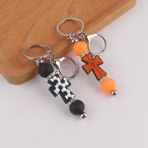 Porte-clés croix en silicone et détail de breloque de sac, pendentif en métal élégant.