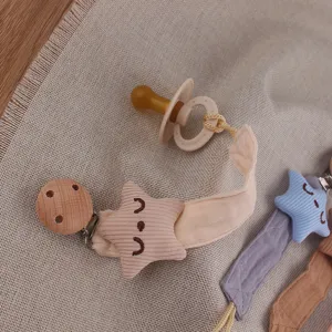 Close-up detail view of baby pacifier clip set featuring cute star plush and wooden clip.