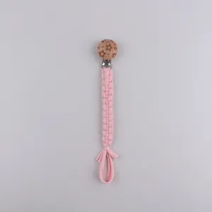 Handmade braided baby pacifier clip with cute flower wooden button and secure pink strap.