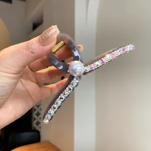 Gros plan détaillé de la pince à cheveux grise élégante décorée de strass brillants.