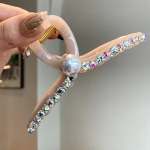 Gros plan détaillé de la pince à cheveux élégante en perles et strass pour chignons chics.